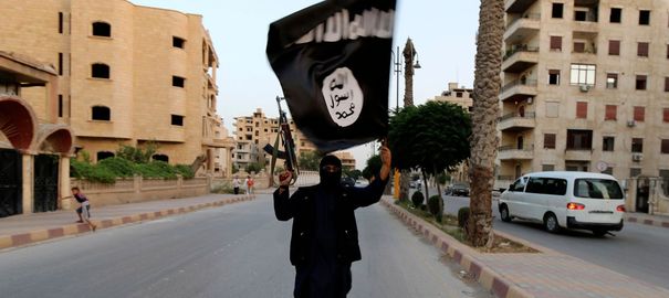 a-member-loyal-to-the-isil-waves-an-isil-flag-in-raqqa_4945617
