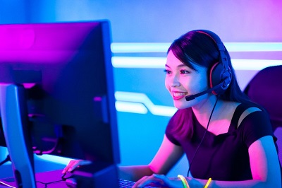 femme qui joue au jeux videé sur un pc gamer