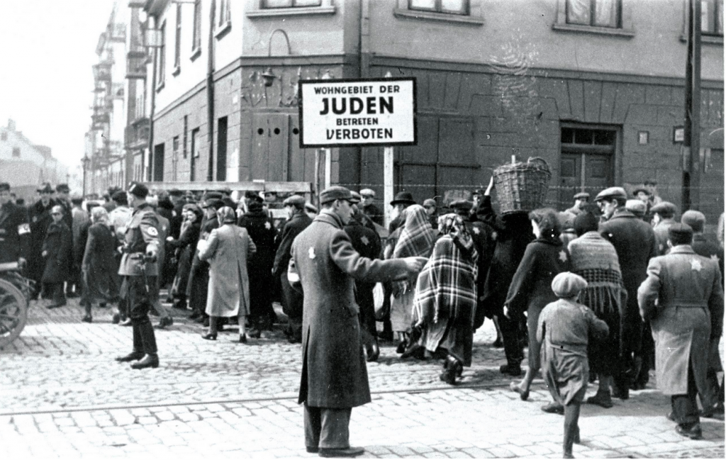 Un soldat allemand et un policier juif surveillent la circulation vers le ghetto. Sur le panneau : « Quartier juif, entrée interdite ».