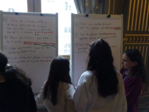 des enfants lisent des affiches où sont inscrites des propositions concernant la'ccueil des enfant migrants