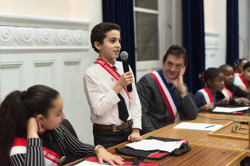 un enfant élu parle au micro pour se présenter 