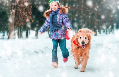 jeune fille qui se balade en courant avec son chien dans la neige